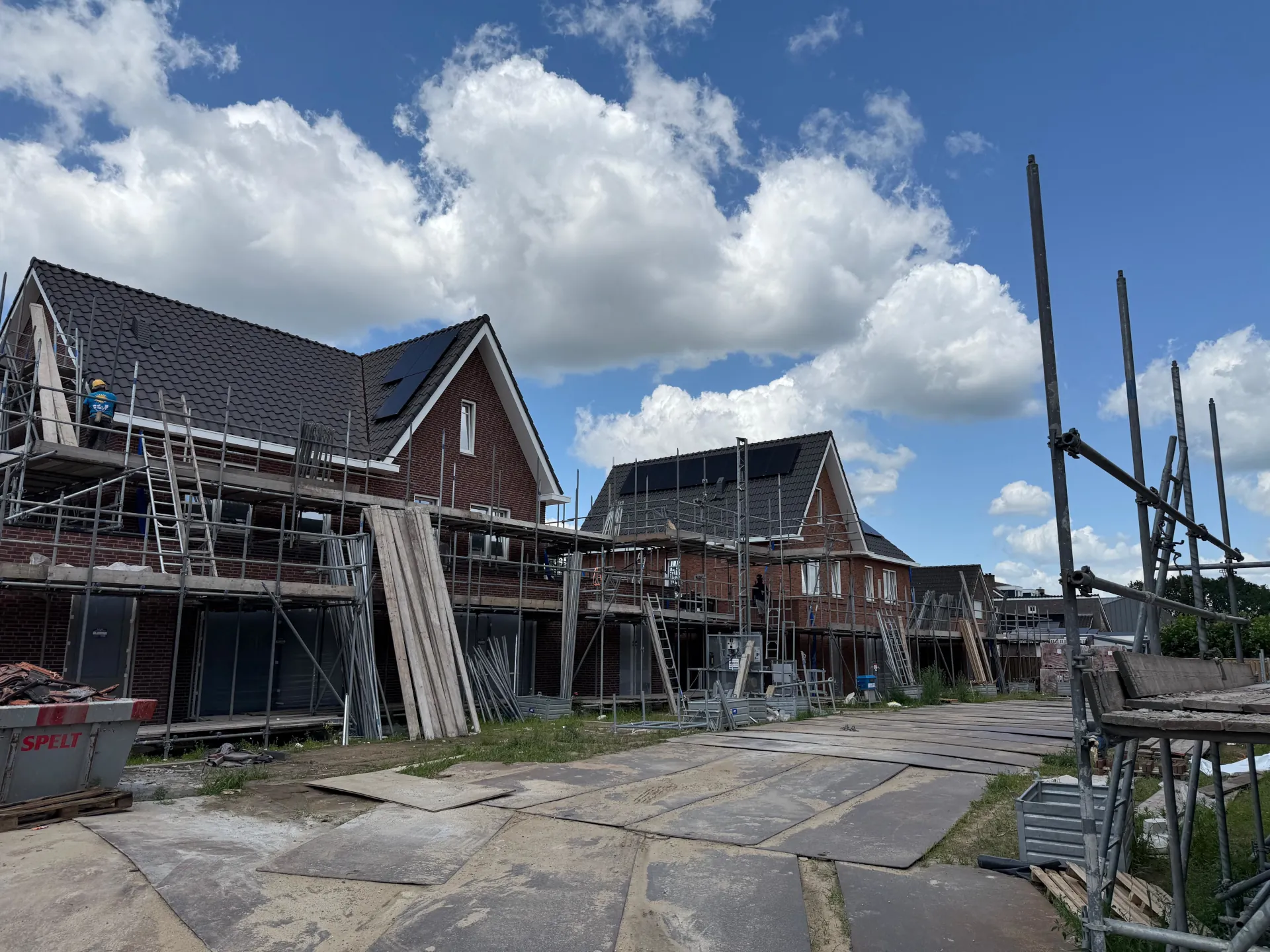 Bouw van nieuwbouwwoningen in Oostrum met geplaatste dakconstructies en steigers
